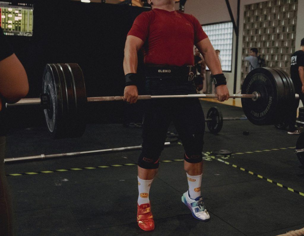 Weightlifter performs a deadlift with a heavy barbell.